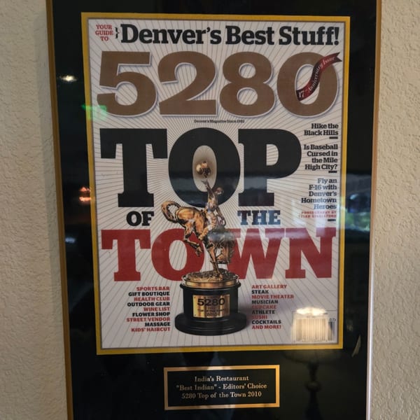 Framed 5280 Magazine cover, "Top of the Town" award, and "Best Indian" recognition for INDIA'S Restaurant.
