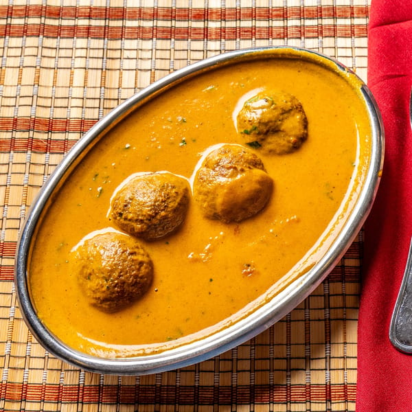 Malai Kofta, a creamy Indian dish with vegetable and paneer balls in a rich orange sauce.